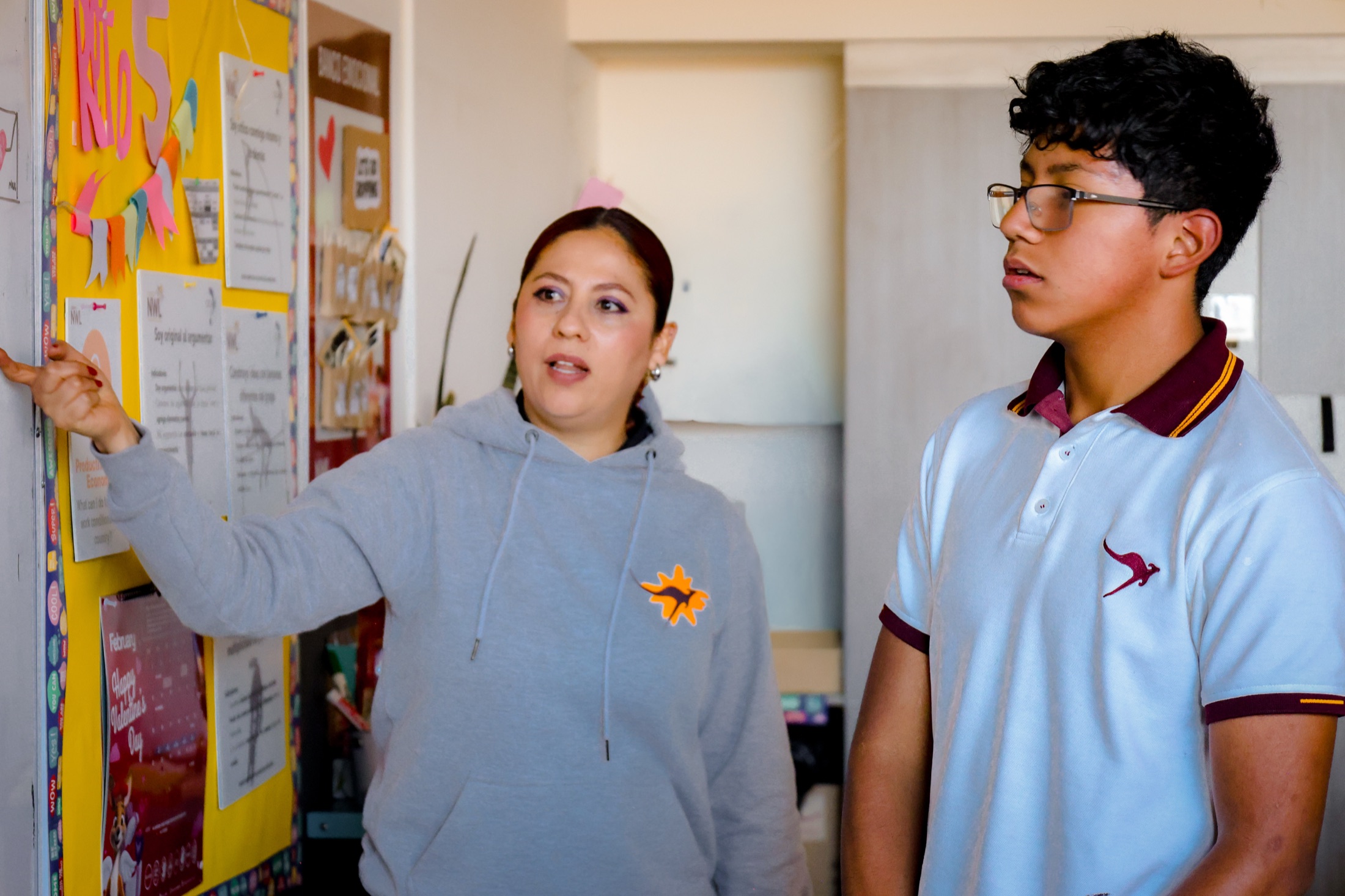 Newland teacher explaining concept at whiteboard with middle school student
